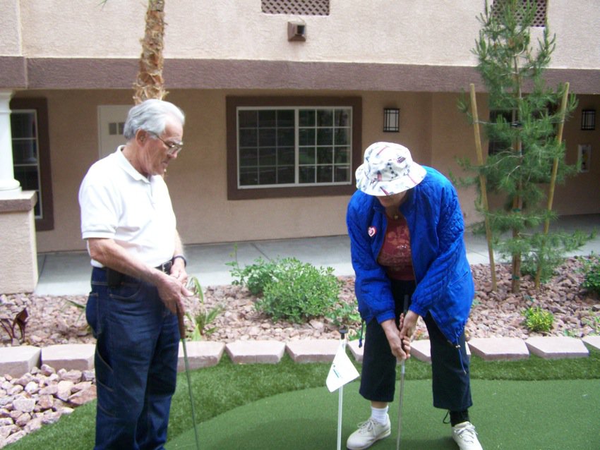 Two Carefree residents playing on the community putting green